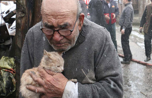 Sobayı benzinle tutuştururken evi yandı... Kedisine sarılarak izledi