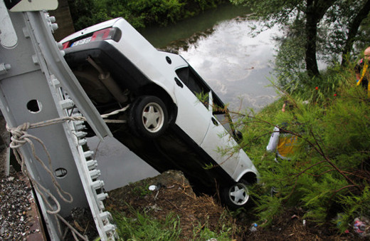 Devrilen otomobil köprü korkuluklarında asılı kaldı