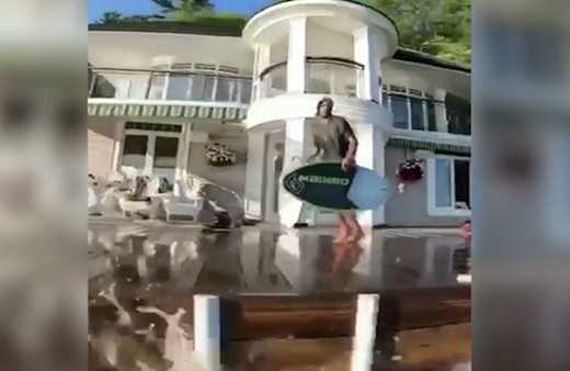 Evinin bahçesinden sörf tahtasıyla denize atladı