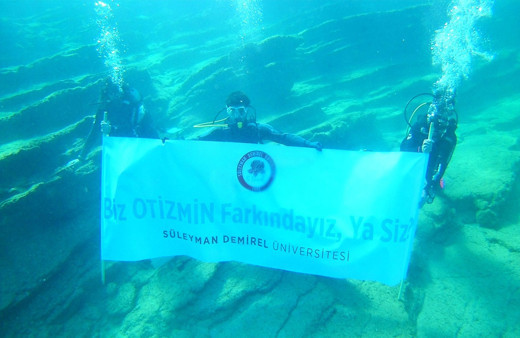 Su altında “Biz otizmin farkındayız, ya siz?” pankartı açtılar