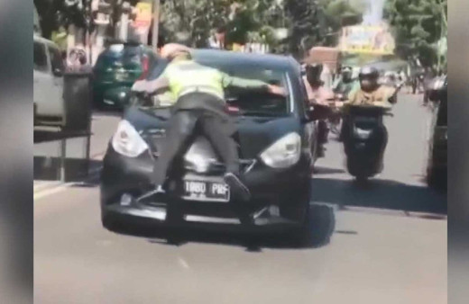 Trafik polisi kırmızı ışıkta geçen otomobilin kaputuna çıktı