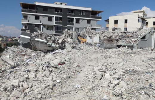 Ağır hasarlı binayı yıkan kepçe operatörü enkaz altında kaldı