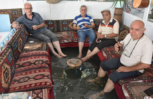 Su kanalı geçen kahvehanede çaylarını yudumlayıp serinliyorlar