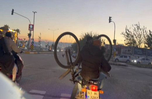 Motosiklet üzerinde bisikletle yolculuk görenleri korkuttu