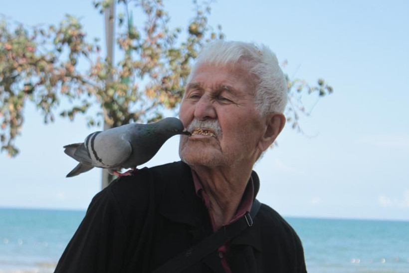 ‘Güvercinci adam’ olarak tanınıyor! Sahilde ağzıyla günde 500 güvercini besliyor... - Resim: 1